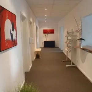 Langer Flur in moderner Arztpraxis mit braunem Steinteppich – hygienischer, fugenloser Bodenbelag für gewerbliche Innenbereiche